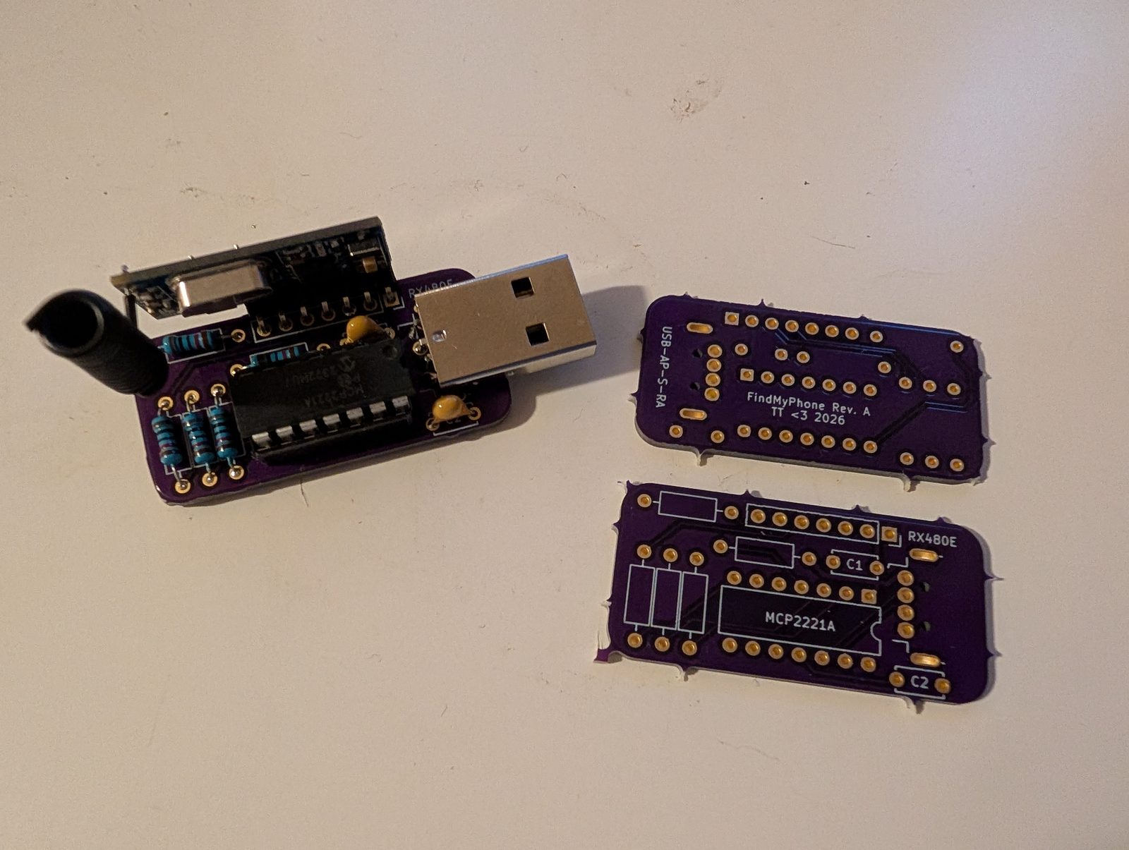 Assembled USB dongle next to two bare boards